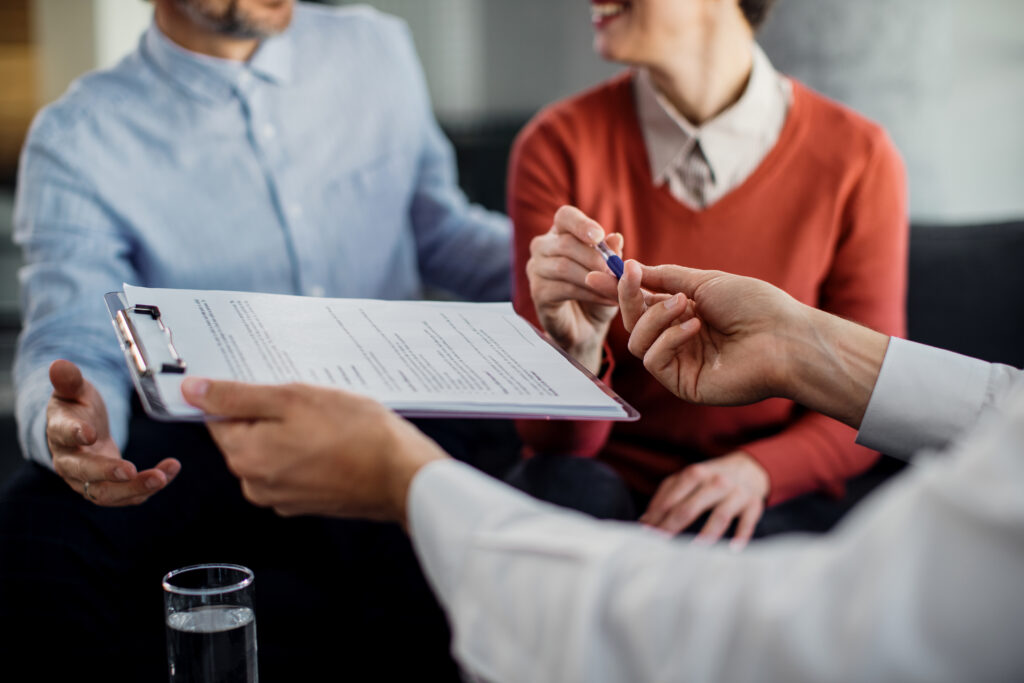 couple signing home insurance contract before buying property in Dubai